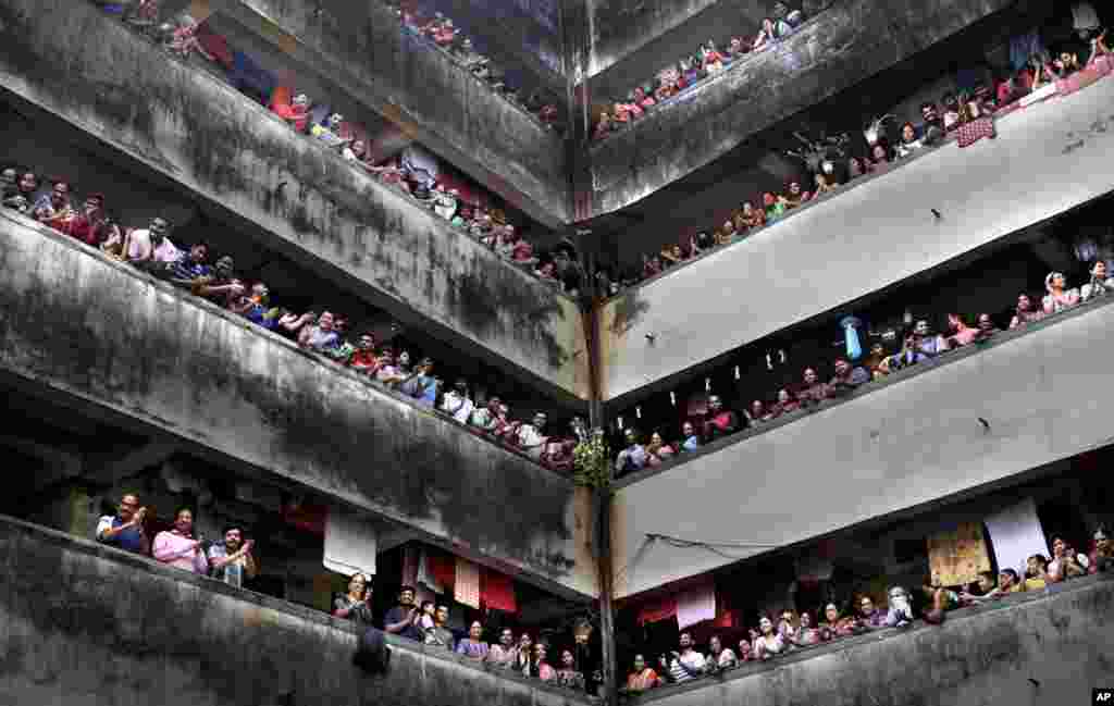 People clap from balconies in show of appreciation to health care workers at a Chawl in Mumbai, India. India observed a 14-hour &quot;people&#39;s curfew&quot; called by Prime Minister Narendra Modi in order to stem the rising coronavirus case in the country.