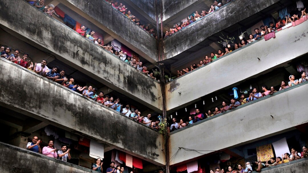 Warga di gedung apartemen di Mumbai, India bertepuk tangan bersama sebagai apresiasi terhadap para petugas medis, Minggu (22/3).