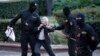 FILE - Opposition activist Nina Baginskaya, 73, center, struggles with police during a Belarusian opposition supporters rally at Independence Square in Minsk, Aug. 26, 2020.