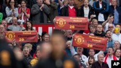 Para pendukung Manchester United mengacungkan spanduk-spanduk mendukung klub kesayangan mereka dalam laga Liga Utama Inggris antara Manchester United dan Chelsea di Stadion Old Trafford, Manchester, Inggris, 5 Mei 2013.
