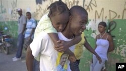 Man carries girl who has symptoms of cholera at entrance of St. Catherine hospital in Cite Soleil neighborhood, in Port-au-Prince, 11 Nov 2010