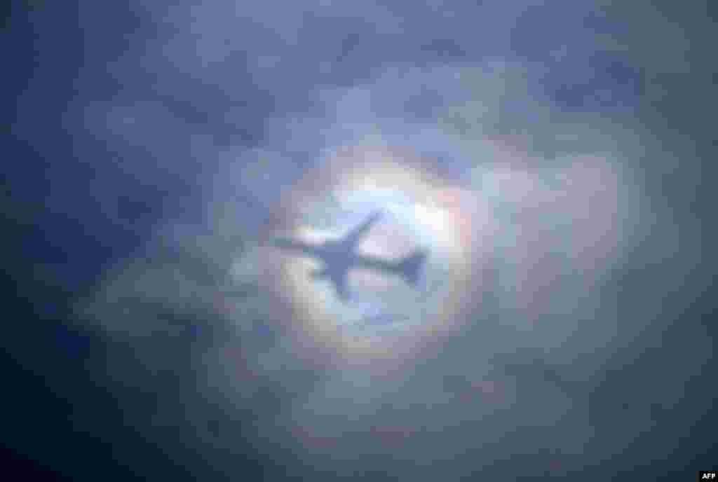 The sun casts a shadow and spectral halo effect on clouds as U.S. Secretary of State's aircraft departs from Tel Aviv, Israel on its way to Geneva, Switzerland for talks with Iran.
