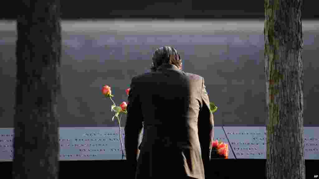 A man stands at the edge of a waterfall pool at ground zero during a ceremony on the 16th anniversary of the 9/11 attacks in New York, Sept. 11, 2017. 