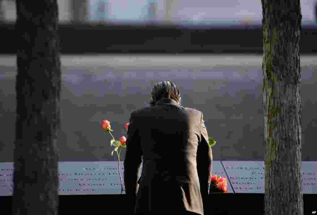 A man stands at the edge of a waterfall pool at ground zero during a ceremony on the 16th anniversary of the 9/11 attacks in New York, Sept. 11, 2017.