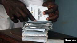 A man searches for his voting card at a polling station in Cameroon's capital, Yaounde (file photo).