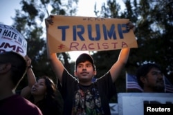 FILE - People protest outside the Luxe Hotel, where Republican presidential candidate Donald Trump was expected to speak in Brentwood, Los Angeles, California, July 10, 2015.