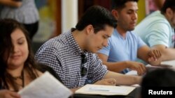 Ernesto Delgado, center, a Deferred Action for Childhood Arrivals (DACA) recipient, fills out his renewal application during the immigration ministry at Lincoln Methodist Church in Chicago, Sept. 10, 2017. 