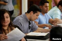 Ernesto Delgado, center, a Deferred Action for Childhood Arrivals (DACA) recipient, fills out his renewal application during the immigration ministry at Lincoln Methodist Church in Chicago, Sept. 10, 2017. DACA recipients gathered to fill out applications to renew their permit before the October 5 deadline for current beneficiaries.