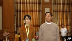 Burma's pro-democracy leader Aung San Suu Kyi (L) poses with Lower House Parliamentary Speaker Shwe Man during her visit to the parliament in the capital Naypyitaw, December 23, 2011.