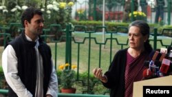 Chief of India's ruling Congress party Sonia Gandhi (R) speaks as her son, lawmaker Rahul Gandhi, watches during a news conference in New Delhi, Dec. 8, 2013.