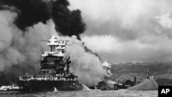 FILE - In this Dec. 7, 1941 file photo, part of the hull of the capsized USS Oklahoma is seen at right as the battleship USS West Virginia, center, begins to sink after suffering heavy damage, while the USS Maryland, left, is still afloat in Pearl Harbor, Oahu, Hawaii. A Navy seaman killed in the attack is being buried with full military honors nearly 75 years after the bombing.