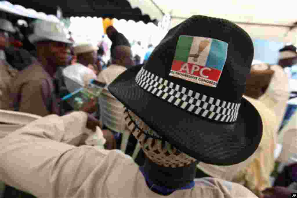 A man wears a hat with the logo of the new All Progressive Congress party's logo over his Muslim prayer cap in Lagos, Nigeria, on Thursday, April 18, 2013.