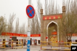 资料照：新疆一清真寺上挂着“爱国爱党”的标语横幅。（2021年3月20日）