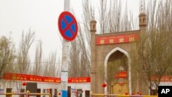 Sebuah masjid dengan spanduk "Cintai Pesta, Cintai Negara" terlihat di dekat daerah Shule di Daerah Otonomi Uyghur Xinjiang, China barat laut, 20 Maret 2021. (Foto: AP)