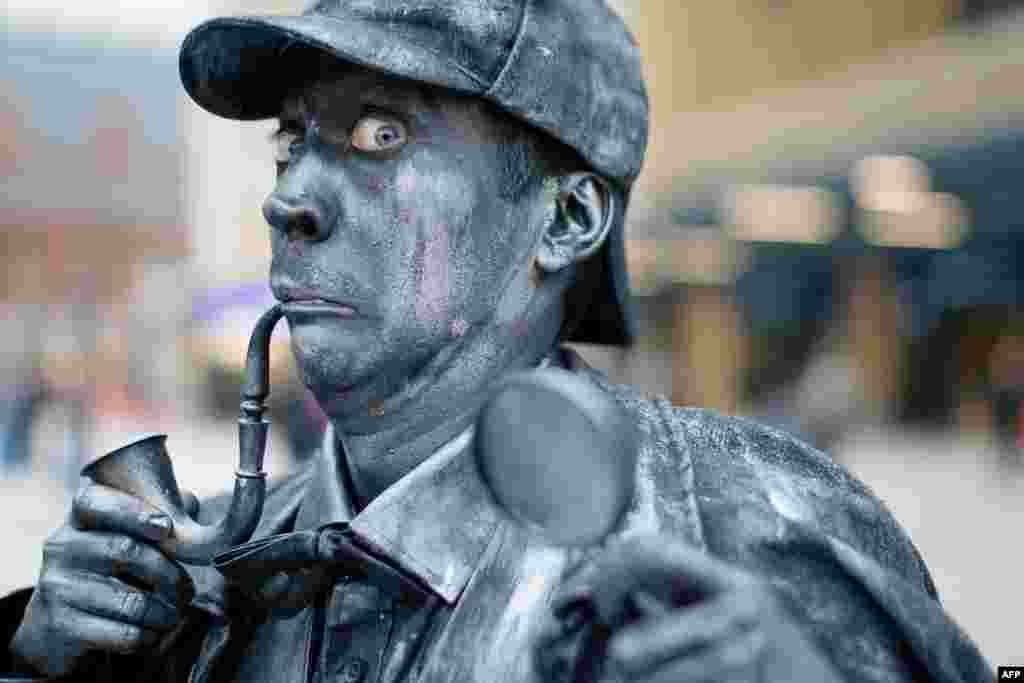 A performer poses as a Sherlock Holmes human statue at King's Cross Square, the new public area outside the central London rail station.