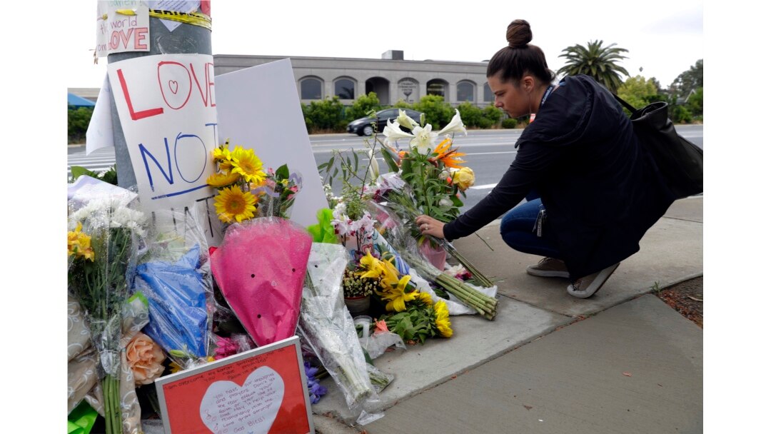 FILE - A woman leaves flowers on a growing memorial across the street from the Chabad of Poway synagogue in Poway, California, April 29, 2019.