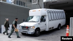 FILE - A vehicle carrying asylum-seekers brought from Tijuana, Mexico, to the United States for their immigration hearings arrives at a court in San Diego, Calif., March 19, 2019.