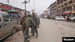 An Indian Central Reserve Police Force (CRPF) personnel frisks a man at a street in Srinagar, Feb. 18, 2019.