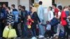 Migrants line up after arriving at a train station in Vienna, Sept. 12, 2015. 