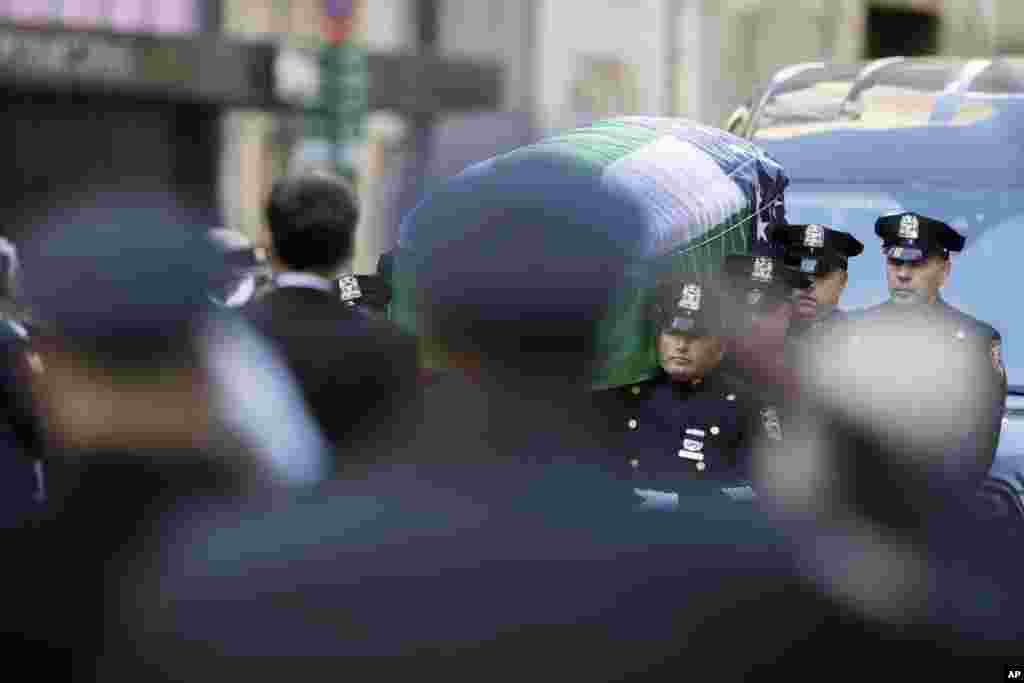 Police officers salute as pallbearers carry the casket of New York City police officer Steven McDonald after his funeral service at St. Patrick&#39;s Cathedral in New York. McDonald died on Tuesday, 30 years after a robbery suspect shot him in Central Park. The officer publicly forgave his assailant and went on to become an international voice for peace.