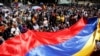 FILE - Anti-government demonstrators wave a Venezuelan flag during a protest against President Nicolas Maduro in Caracas, Aug. 12, 2017. 