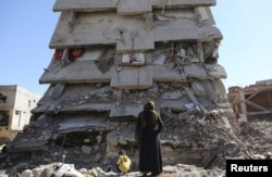 FILE - A woman looks at a building, which was damaged during the security operations and clashes between Turkish security forces and Kurdish militants, in the southeastern town of Cizre in Sirnak province, Turkey, March 2, 2016.