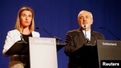 European Union foreign policy chief Federica Mogherini, left, issues a statement with Iran's Foreign Minister Mohammad Javad Zarif in Lausanne, Switzerland, April 2, 2015.