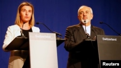 European Union foreign policy chief Federica Mogherini, left, issues a statement with Iran's Foreign Minister Mohammad Javad Zarif in Lausanne, Switzerland, April 2, 2015.