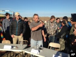 FILE - Robert F. Kennedy Jr., center, an environmental attorney and president of the New York-based Waterkeeper Alliance, speaks with opponents of the Dakota Access oil pipeline at the main protest camp, Nov. 15, 2016, near Cannon Ball, North Dakota.