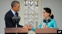 U.S. President Barack Obama, left, and Myanmar's opposition leader Aung San Suu Kyi shake hands during a news conference at her home in Yangon, Myanmar, Nov. 14, 2014.