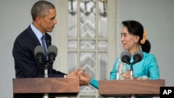 U.S. President Barack Obama, left, and Myanmar's opposition leader Aung San Suu Kyi shake hands during a news conference at her home in Yangon, Myanmar, Nov. 14, 2014.