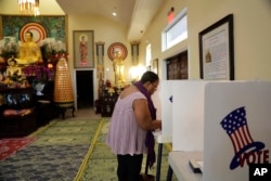 Denise Richardson casts her vote at Chua Phat To Gotama Temple on Tuesday, Nov. 8, 2016, in Long Beach, Calif. (AP Photo/Jae C. Hong)