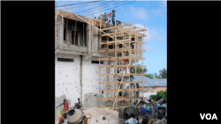 Construction workers restore a Bakara Market business destroyed in the August, 2011 fighting. (Pete Heinlein, VOA)