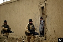 Arhiva - Britanski vojnici iz međunarodne koalicije predvođene NATO-om patroliraju dok ih afganistanska djeca posmatraju u Kabulu, Afganistan, 27. januara 2006.