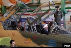Iranian President Hassan Rouhani inspects the cockpit of what Iran calls its new domestically designed Kowsar fighter jet, Aug. 21, 2018.