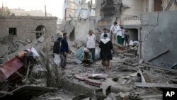 FILE - People inspect the damage of houses destroyed by Saudi-led airstrikes in Sanaa, Yemen, Jun. 9, 2017. 