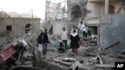 FILE - People inspect the damage of houses destroyed by Saudi-led airstrikes in Sanaa, Yemen, Jun. 9, 2017. 
