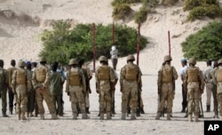 FILE - Hassan Hanafi Haji, center, a former journalist accused of belonging to al-Shabab and involvement in the killings of five Somali journalists, is tied to a wooden post as he is prepared to be executed by firing squad in the capital Mogadishu, Somalia, April 11, 2016.
