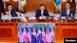 문재인 한국 대통령이 12일 청와대 내각 회의 중 미북정상회담을 실시간 생중계로 보고 있다. 