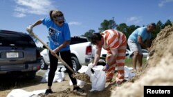 An inmate with the Hancock County Department of Corrections helps Janice Labat fill a bag with sand as Tropical Storm Gordon approaches Bay St. Louis, Mississippi, Sept. 4, 2018.