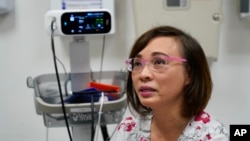 Clinical nurse Tram Pham becomes teary eyed remembering how hard it was at first, adjusting to life in the U.S. as a refugee from Vietnam at the Valley Health Center TB/Refugee Program in San Jose, California, on Dec. 9, 2021.