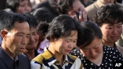 မြောက်ကိုရီးယားမြို့တော် ပြုံယမ်းမှာ ဆောက်လက်စတိုက်ခန်းတွေ ပြိုကျပြီး သေဆုံးသူတွေရဲ့ မိသားစုဝင်များ။ (မေ ၁၈၊ ၂၀၁၄)