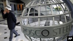 A man walks past a logo of steelmaker POSCO at the company's headquarters in Seoul, (File)