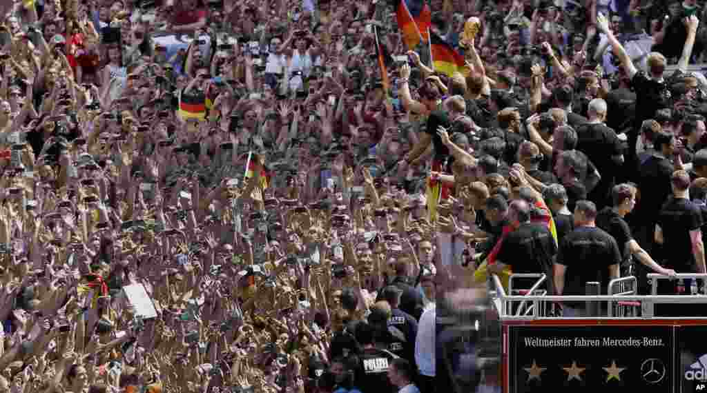 Members of the German soccer team wave to fans, in Berlin, July 15, 2014.