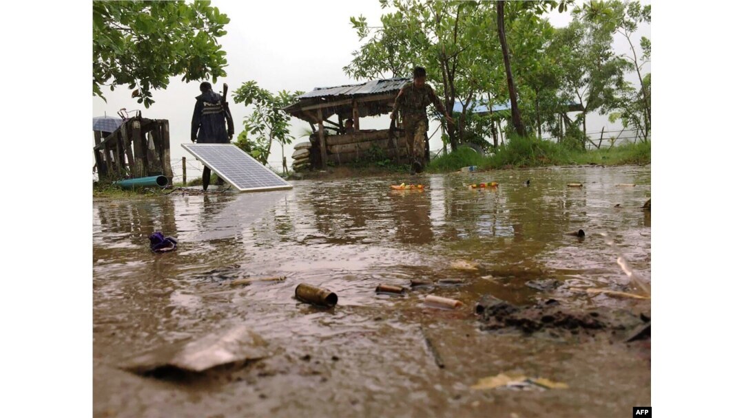 FILE - Two Myanmar policemen monitor a checkpoint at the entrance of Yathae Taung township in Rakhine State, Aug. 26, 2017.