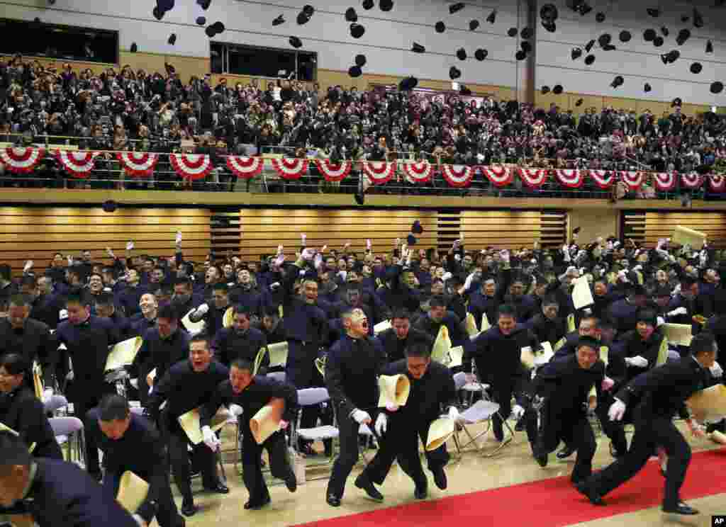 Graduating cadets toss their caps in the air during the commencement ceremony at Japan&#39;s National Defense Academy in Yokosuka, near Tokyo.