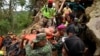 Rescue workers carry a miner who survived the collapse of an illegal gold mine at Bolaang Mongondow regency in North Sulawesi, Indonesia, Feb. 28, 2019.