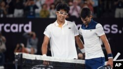 South Korea's Chung Hyeon, left, is congratulated by Serbia's Novak Djokovic after winning their fourth round match at the Australian Open tennis championships in Melbourne, Australia, Monday, Jan. 22, 2018. (AP Photo/Andy Brownbill)