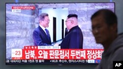 A TV screen shows South Korean President Moon Jae-in, left, meeting with North Korean leader Kim Jong Un at the border village of Panmunjom during a news program at the Seoul Railway Station in Seoul, South Korea, May 26, 2018.