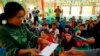 Police give aid to people fleeing from Laukkai, the capital of Kokang in Shan State, who arrived at a monastery functioning as a refugee camp in Lashio, Feb. 16, 2015. 